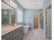 Bright bathroom showcasing a soaking tub, dual sink vanity, and a glass-enclosed shower at 1013 Poppy Fields Ln, Wake Forest, NC 27587