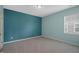Modern bedroom with a bold blue accent wall, soft gray carpet, and ample natural light at 1013 Poppy Fields Ln, Wake Forest, NC 27587