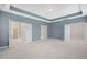The spacious primary bedroom offers ensuite access, a tray ceiling and a neutral color palette for a relaxing retreat at 1013 Poppy Fields Ln, Wake Forest, NC 27587