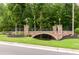 Charming stone bridge with decorative railings and lighting amidst a green landscape at 1013 Poppy Fields Ln, Wake Forest, NC 27587