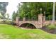 Attractive stone bridge with manicured lawn, shrubbery and mature trees at 1013 Poppy Fields Ln, Wake Forest, NC 27587