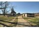 Exterior view of log cabins with a paved path surrounded by grass, trees, and a clear sky at 1013 Poppy Fields Ln, Wake Forest, NC 27587