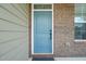 Charming blue front door with a classic design, complemented by brick and siding at 1013 Poppy Fields Ln, Wake Forest, NC 27587