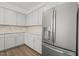 Bright kitchen features gray cabinets, granite countertops, tiled backsplash, stainless fridge, and hardwood floors at 1013 Poppy Fields Ln, Wake Forest, NC 27587