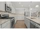 Well-equipped kitchen with stainless steel appliances, granite countertops, and stylish gray cabinetry at 1013 Poppy Fields Ln, Wake Forest, NC 27587