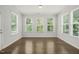 Sunlit living room featuring hardwood floors and three large windows at 1013 Poppy Fields Ln, Wake Forest, NC 27587