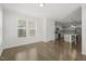 Open floor plan of living room leading to kitchen with hardwood flooring and lots of natural light at 1013 Poppy Fields Ln, Wake Forest, NC 27587