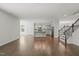 Open-concept living space featuring hardwood floors, a staircase, and an adjacent kitchen with an island at 1013 Poppy Fields Ln, Wake Forest, NC 27587