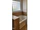 Bright bathroom featuring a soaking tub with tile surround and natural light through a glass block window at 1016 Dotson Way, Apex, NC 27523