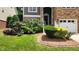 Close-up of the front yard featuring lush landscaping, colorful flowers, and a well-manicured lawn at 1016 Dotson Way, Apex, NC 27523