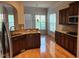 Well-lit kitchen with wood floors, countertops, and cabinetry plus stainless steel refrigerator at 1016 Dotson Way, Apex, NC 27523
