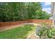 Beautiful backyard with lush green grass, tall trees, and a wooden fence at 1016 Goldmist Ln, Durham, NC 27713