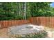 Backyard presents a fenced yard with a fire pit and stone, ideal for outdoor gatherings at 1016 Goldmist Ln, Durham, NC 27713