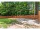 Exterior backyard featuring a fire pit, wooden fence, and tree-lined surroundings at 1016 Goldmist Ln, Durham, NC 27713