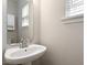 Half bathroom featuring a single sink with large mirror and window at 1016 Goldmist Ln, Durham, NC 27713