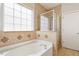 Bright bathroom featuring a tub and separate glass-door shower at 1016 Goldmist Ln, Durham, NC 27713