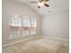 Bright bedroom with vaulted ceiling, ceiling fan, and three large windows at 1016 Goldmist Ln, Durham, NC 27713
