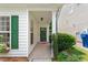 Welcoming front porch with green shutters and door, complemented by decorative plants at 1016 Goldmist Ln, Durham, NC 27713