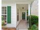 Inviting front porch with green door, adorned with a wreath, and lush green shrubbery at 1016 Goldmist Ln, Durham, NC 27713