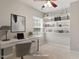 Bright home office featuring built-in shelving, a modern desk, and a ceiling fan at 1016 Goldmist Ln, Durham, NC 27713