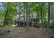 Back of house featuring large deck and screened-in porch surrounded by mature trees at 105 Gorge Ct, Cary, NC 27518
