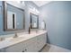 Bathroom with double sinks, white cabinets, and decorative mirrors and fixtures at 105 Gorge Ct, Cary, NC 27518