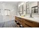 Modern bathroom with double sinks, wooden cabinets, marble tile, and stylish fixtures at 105 Gorge Ct, Cary, NC 27518