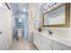 Bright bathroom features white vanity, framed mirror, and a shower-tub combination with neutral tile at 105 Gorge Ct, Cary, NC 27518