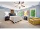 Spacious bedroom featuring a ceiling fan, a cozy chair, and natural light from the windows at 105 Gorge Ct, Cary, NC 27518
