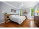 Serene bedroom with a large bed, hardwood floors, and windows offering a view of the trees at 105 Gorge Ct, Cary, NC 27518