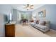 Cozy living room featuring a comfortable sofa, desk, and natural light from the bay windows at 105 Gorge Ct, Cary, NC 27518
