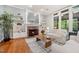Elegant living room showcasing a fireplace, built-in shelving, hardwood floors, and large windows at 105 Gorge Ct, Cary, NC 27518