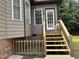 Back porch featuring wooden steps, a white door and decorative railings at 105 Perry Ln, Zebulon, NC 27597