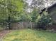 View of fenced backyard featuring a gate leading into a wooded area at 105 Perry Ln, Zebulon, NC 27597