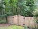 Wooden backyard gate surrounded by mature trees providing additional privacy at 105 Perry Ln, Zebulon, NC 27597