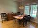 Well-lit dining room featuring hardwood floors, a dark table and wood chairs at 105 Perry Ln, Zebulon, NC 27597