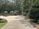 Long concrete driveway leading up to the home with a partially fenced yard at 105 Perry Ln, Zebulon, NC 27597