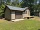 View of the accessory building, showing the garage door, door to the exterior, and small deck at 105 Perry Ln, Zebulon, NC 27597