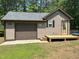 Large garage featuring a new deck, garage door, and a Personal door at 105 Perry Ln, Zebulon, NC 27597