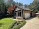 A well-maintained home with a garage, trimmed flowerbeds, green lawn and a vibrant red maple at 105 Perry Ln, Zebulon, NC 27597
