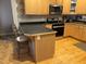 Kitchen with stainless appliances, wood cabinetry, breakfast bar, and hardwood floors at 105 Perry Ln, Zebulon, NC 27597