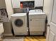 Modern laundry room with a front-load washer, dryer, and overhead cabinets for efficient storage at 105 Perry Ln, Zebulon, NC 27597