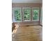 Sun-drenched sunroom with hardwood floors and large windows offering green view at 105 Perry Ln, Zebulon, NC 27597