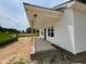 A new build featuring siding and a concrete porch supported by wooden posts, with a dumpster nearby for easy cleanup at 107 Lynn Ln, Selma, NC 27576