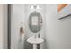 Elegant powder room featuring a pedestal sink and decorative mirror at 108 Hundred Oaks Ln, Holly Springs, NC 27540