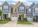 Charming townhomes featuring colorful exteriors, attached garages, and manicured lawns in a friendly community at 108 Hundred Oaks Ln, Holly Springs, NC 27540