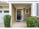 Inviting front entry featuring a dark door, wreath, covered porch, and well-maintained landscaping at 108 Hundred Oaks Ln, Holly Springs, NC 27540