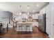 Well-appointed kitchen with white cabinets, granite counters, stainless appliances, and an island with seating at 108 Hundred Oaks Ln, Holly Springs, NC 27540