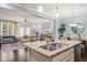 Open concept kitchen with stainless steel sink, granite countertops, and views into the living and dining areas at 108 Hundred Oaks Ln, Holly Springs, NC 27540