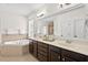 A bathroom with a double vanity, large mirror, and corner bathtub at 108 Teagan Ct, Chapel Hill, NC 27516